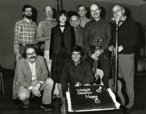 Standing (l.-r.): Doug Mishkin, Pete Seeger, Lydia Adams Davis, Harold Leventhal, Oscar Brand, Tom Paxton, Fred Kellerman, and Joe Heukerott (kneeling) joined Bob Sherman in celebrating Woody's Children's 15th anniversary in 1984 (Photo: Steve J. Sherman)